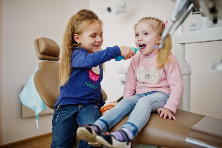 Young girls sitting in a dental chair, illustrating Back to School Dental Tips for kids’ oral health.